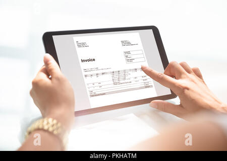 Close-up Of A Businesswoman's Hand Checking Invoice On Digital Tablet Stock Photo