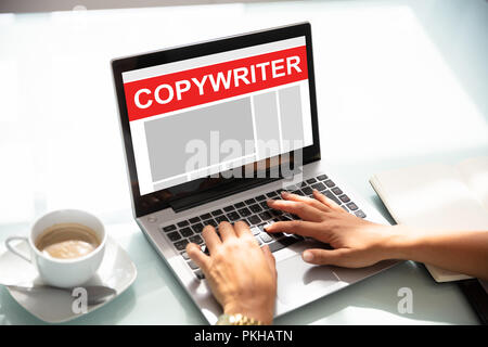 Female Copywriter's Hand Working On Laptop Writing Article In Office Stock Photo