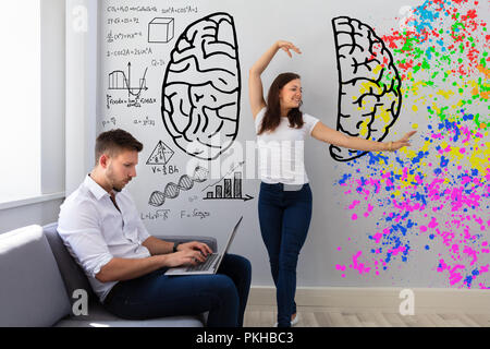 Happy Woman Dancing Near Her Busy Husband Working On Laptop At Home Stock Photo