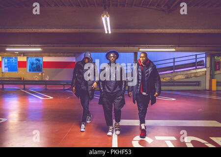three young men walking parking lot - gang, crew, confident concept Stock Photo