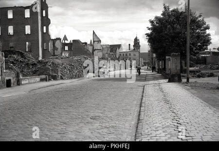 1950s, historical, view down an old cobbled street in the city of Cologne, Germany showing empty bombed out buildings remaining from the allied offensives during the second World War. Stock Photo