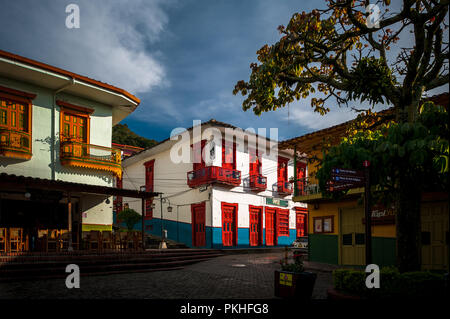 Brightly painted colonial houses are seen on the main plaza during the sunrise in Jericó, a village in the coffee region (Zona cafetera) of Colombia,  Stock Photo