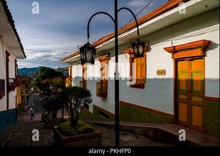 Brightly painted wooden balconies and windows are seen at a colonial house during the sunrise in Jericó, a village in the coffee region (Zona cafetera Stock Photo