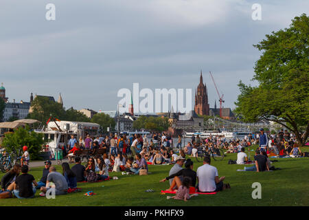 Frankfurt, Germany - April 29, 2018: People enjoying a sunny day next to Main river in the city of Frankfurt, Germany Stock Photo