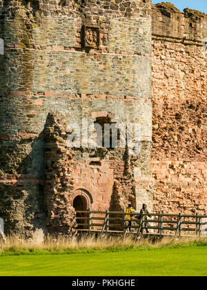 Women walking on moat bridge entrance of 14th century fortified Tantallon Castle, North Berwick, East Lothian, Scotland, UK Stock Photo