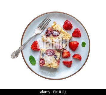 Strawberry plum cake on white plate with strawberries scattered around on white background. Isolated. Stock Photo
