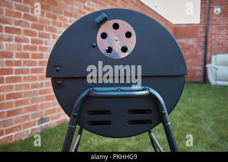 Black big barrel grill in the garden. Stock Photo