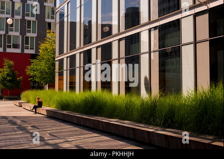 Woman taking a lunch break sitting on bench downtown Seattle. Stock Photo
