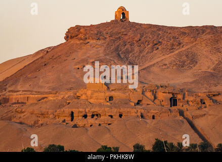Hilltop Muslim prophet tomb Qubbet el-Hawa or Dome of the Winds above ancient rock cut tombs, West Bank of Nile River, Aswan, Egypt, Africa Stock Photo