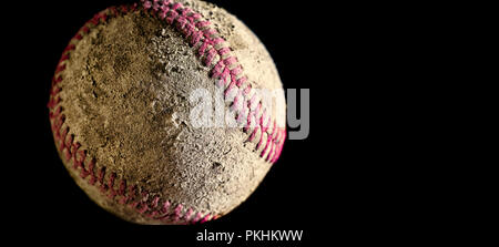 Baseball close up against black background with copy space. Ball is used, rough, dirty, old. Side lighting with sharp focus on texture details. Stock Photo