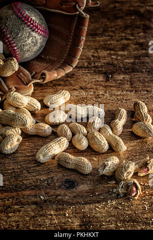 Baseball, glove and ball on rustic wood with scattered peanuts in the shell. Theme for America's favorite sport. Nostalgia concept. Vertical Stock Photo