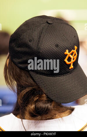 A baseball fan wears a Yomiuri Giants cap at a game at the Tokyo Dome on Sept. 17, 2009. She wears the cap backwards, photo is taken from the back. Stock Photo