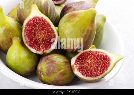Ripe figs in a plate on gray stone background selective focus close up Stock Photo