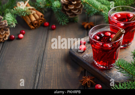 Cranberry Drink on Wooden Background Decorated with Fir Branches, Spices and Fresh Berries, Selective Focus. Stock Photo