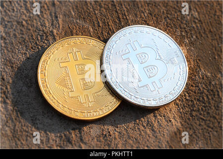 A two coins of bitcoins on pavement with sunlight in golden watch. New era of cryptocurrency is here Stock Photo