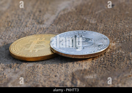 A two coins golden and silver on old pavement known as bitcoin. New era of currency. Money Stock Photo