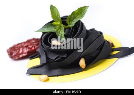 uncoocked blask tagliatelle on gastronomic plate composition Stock Photo