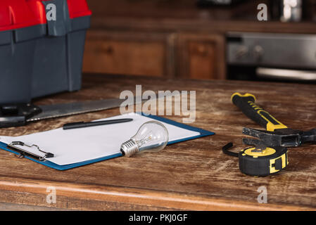 close-up shot of blank clipboard with tools on wooden table Stock Photo