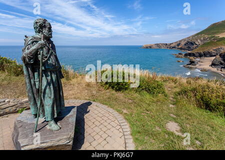 The statue of St Crannog stands overlooking the beach of Llangrannog, Ceredigion, wales Stock Photo