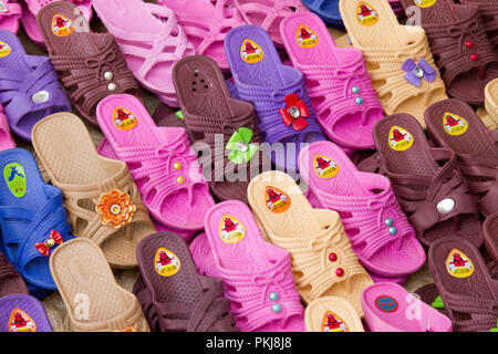Group of colourful plastic shoes for sale at Madagascan farmers market,Madagascar,africa Stock Photo