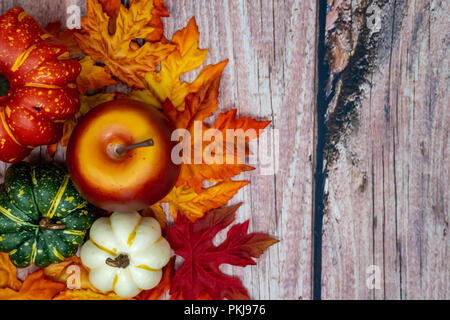 Fall autumn background with apples, leaves and colorful gourds over a wooden background Stock Photo