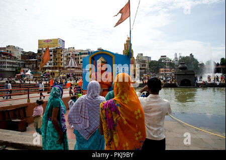 Women Hindu pilgrims watching Lord Hanuman statue on Godavari river Ghat nashik maharashtra India Stock Photo