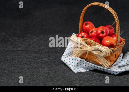 Apples in a straw basket over a black background. Fall and autumn concept, also works for Fourth of July - star napkin Stock Photo