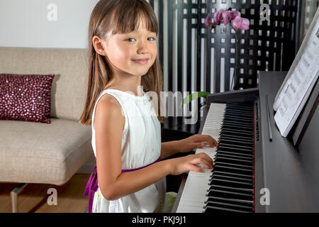 Six year old girl playing the piano Stock Photo