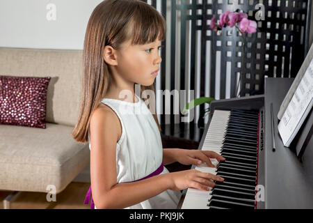 Six year old girl practicing the piano Stock Photo