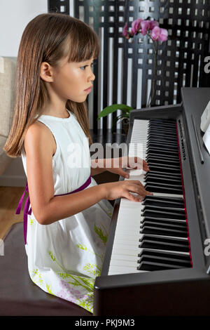 Six year old girl practicing her piano Stock Photo