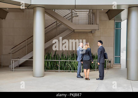 Three executives talking in their office building Stock Photo