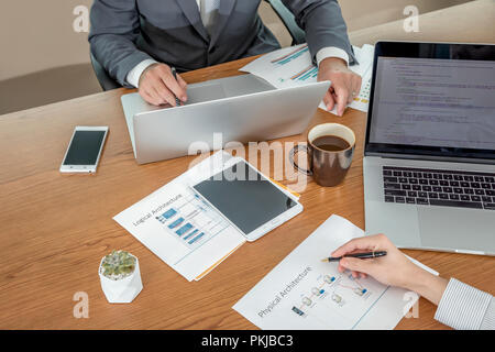 A male and a female colleague working together at the same desk Stock Photo