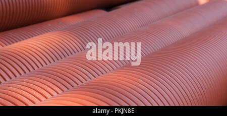 Corrugated water pipes of large diameter prepared for laying, background. Stock Photo