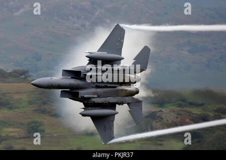 McDonnell Douglas F15E Strike Eagle from RAF Lakenheath generating it's own clouds on a low level training flight in Wales Stock Photo