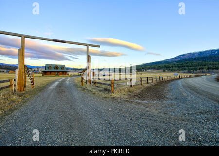 Entry gate to a nice wooden ranch home with beautiful landscape. Northwest, USA. Stock Photo