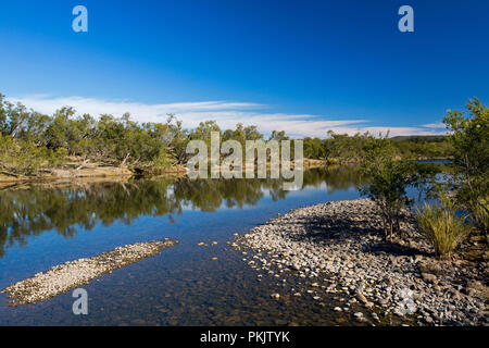 Calm blue waters of Clarence River slicing through forested landscape under blue sky in northern NSW Australia Stock Photo