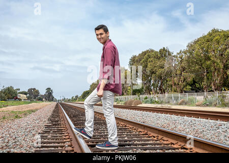 Young male standing on railway tracks, Carlsbad, California Stock Photo