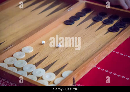 thrown dice on the table while playing backgammon Stock Photo