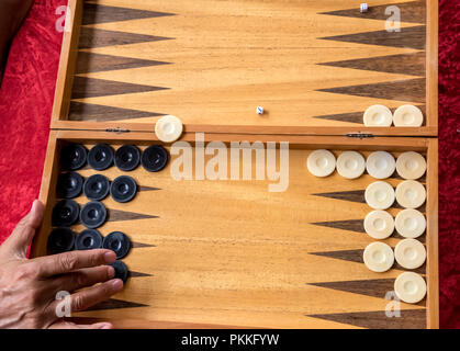 a man moves a checker in a backgammon game Stock Photo