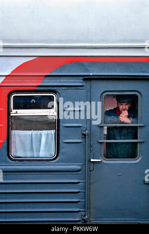 SIBERIA, RUSSIA - MARCH 20, 2018: Russian passenger is watching outside from Trans Siberian Express in Vladivostok, Russia. Stock Photo