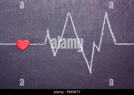 The cardiogram of the heart is painted with chalk on a blackboard. Concept of Love, Valentine's Day Stock Photo