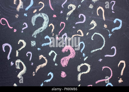 Multicolored question marks are painted with chalk on a blackboard.uncertainty or doubt concept Stock Photo