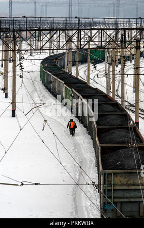 SIBERIA, RUSSIA - MARCH 20, 2018: Railway workers are walking near freight trains around Novosibirsk railway station, Russia. Stock Photo