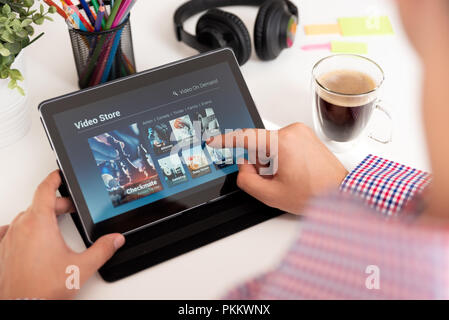 Man using digital tablet for watching movie on VOD service. Video On Demand television internet stream multimedia concept Stock Photo