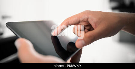 Man using digital tablet. Finger pointing on screen, close up composition Stock Photo