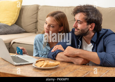 Young couple doing shopping online in internet and using a credit card Stock Photo