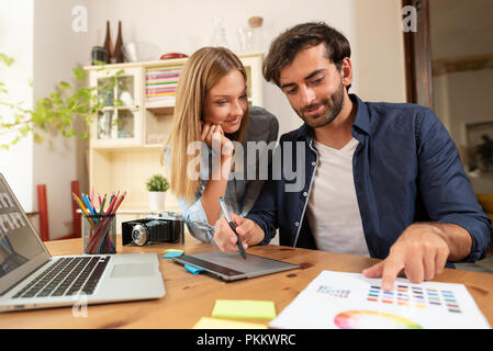 Graphic designers working on the project. Couple of freelancers working at home. Stock Photo