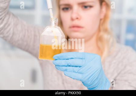 Close up of Young female scientist working in genetics laboratory with pipette in white biological sample Stock Photo