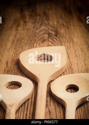 Three woden cooking spoon on a rustic kitchen table, selective focus on foreground Stock Photo