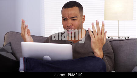 Black guy streaming the game on his laptop Stock Photo